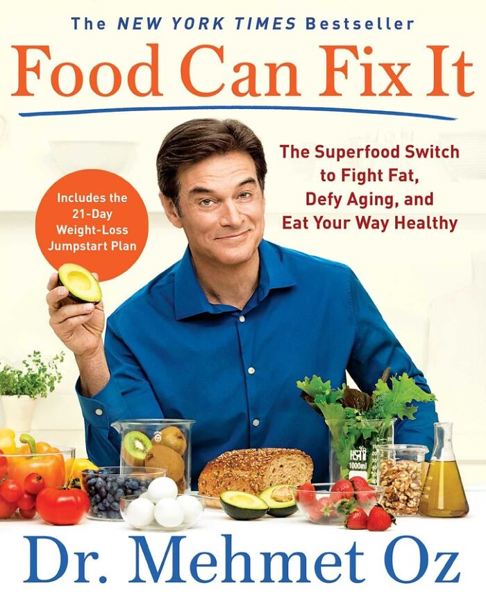 Dr. Oz in a blue shirt holding avocado, surrounded by healthy foods promoting weight loss and eating less during holidays.