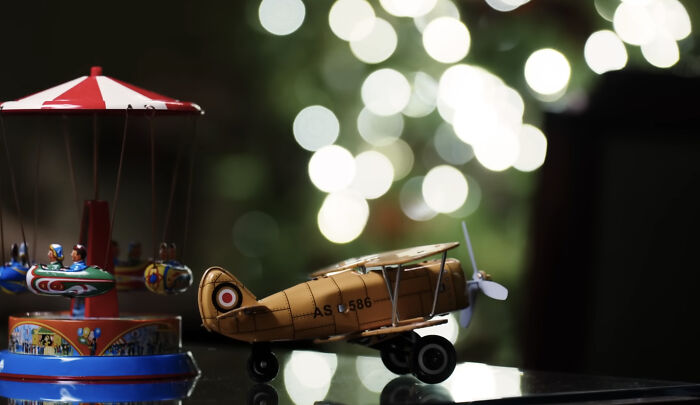 Melania Trump&rsquo;s 2025 Christmas decorations featuring vintage toy airplane and carousel with festive bokeh lights in the background