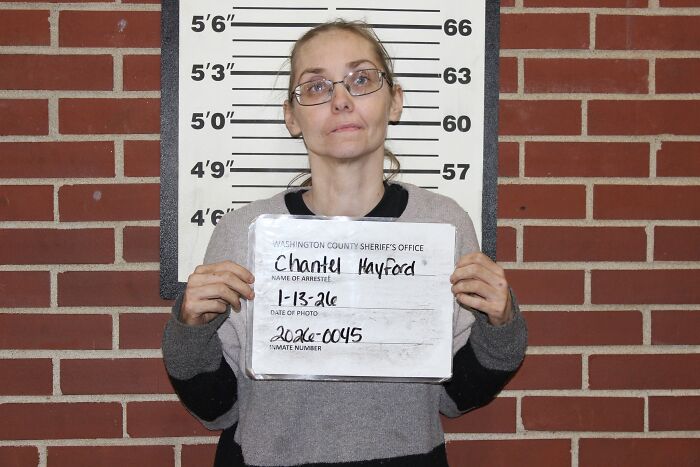 Mugshot of woman in front of height chart after Missouri couple charged in teen chicken pen fight case