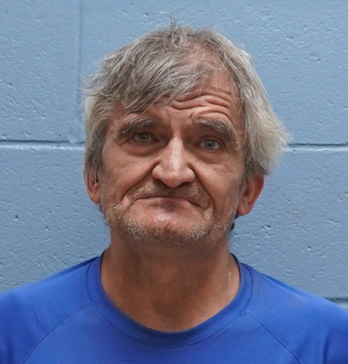 Middle-aged man with gray hair wearing a blue shirt against a blue wall in connection to dogs found deceased case.