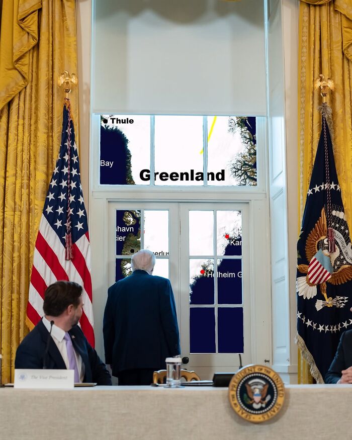 Man standing by window with Greenland map, U.S. flags nearby, symbolizing lawmakers blocking invasion of NATO territory.