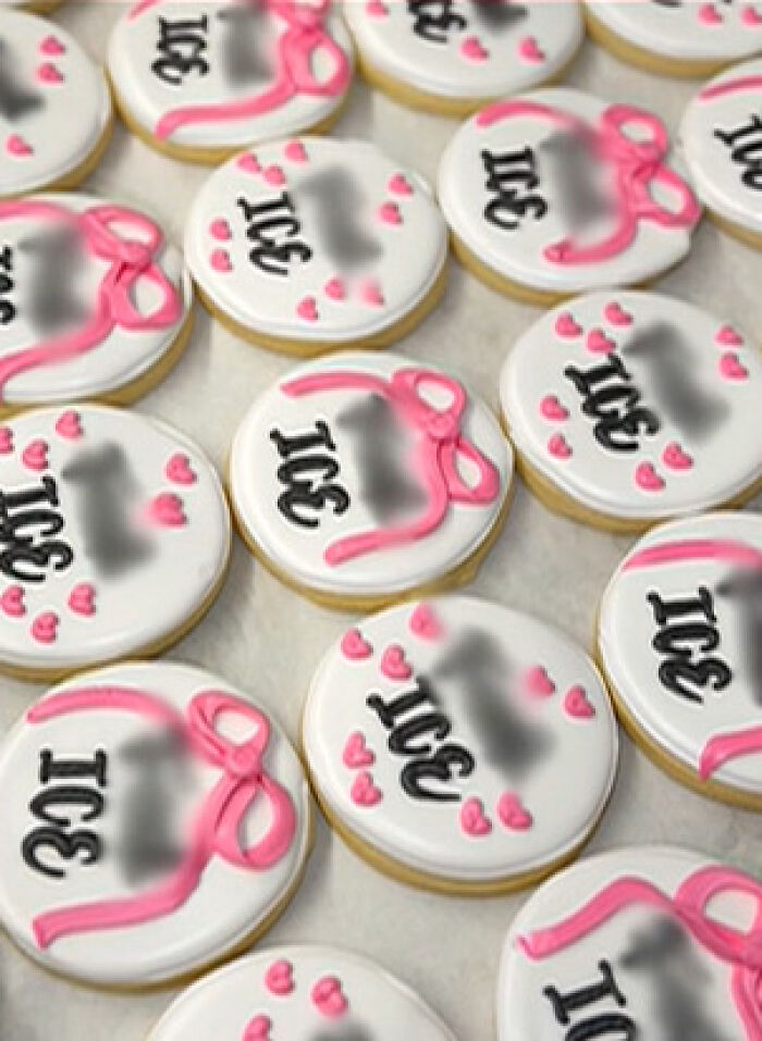 Round decorated cookies with anti-ICE messages and pink hearts displayed on a surface at a local bakery.