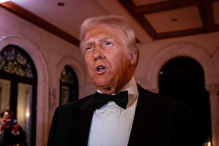 Former president in a black tuxedo at a formal event, amid discussions of lavish NYE blowout and rising health costs.