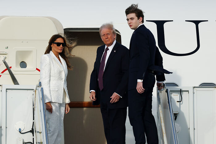 Melania Trump with Donald Trump and Barron Trump boarding a plane, highlighting parenting Barron at 19 as a nonstop job.