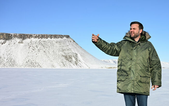 Man in green parka gesturing outdoors on snowy landscape highlighting Trump Greenland deadline dispute.