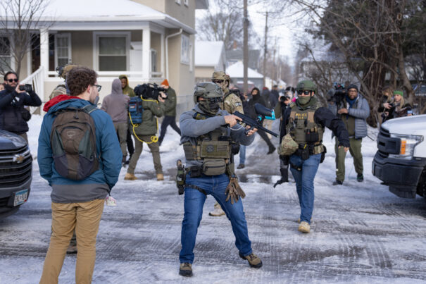 Heavily armed police and activists confront each other on a snowy street during tensions over anti-ICE cookies at local bakery.