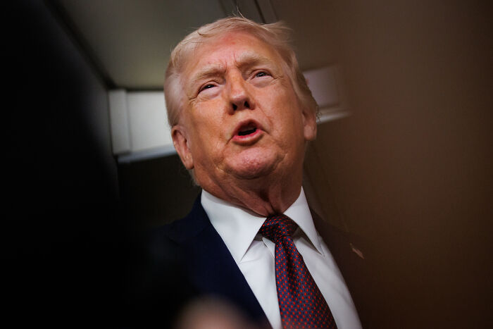 Donald Trump speaking indoors, captured during a moment of turbulence aboard Air Force One, referencing press secretary.