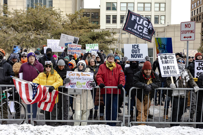 Demonstrators protesting ICE outside a Minnesota church, holding signs and banners against immigration enforcement.