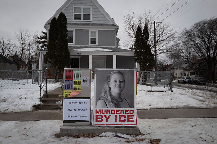 Protest sign reading m******d by ICE displayed outside Minnesota house during demonstration against ICE pastor.