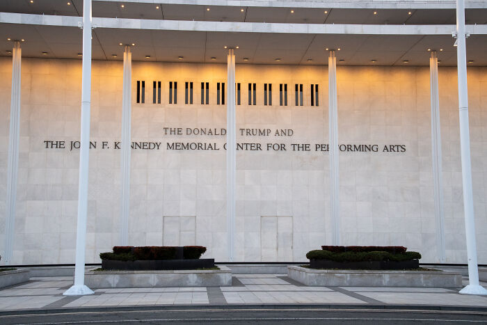 The exterior of the Kennedy Center with Philip Glass symphony cancellation linked to current leadership.
