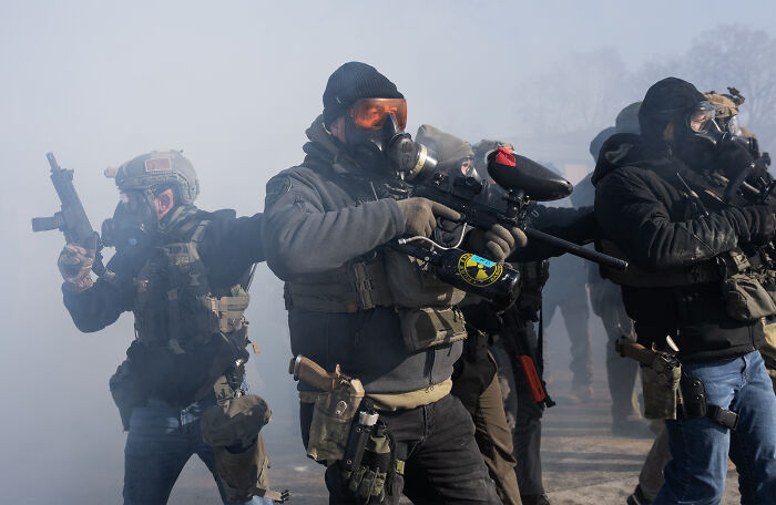 Group of armed tactical operators wearing protective gear and masks, representing 2nd Amendment and NRA themes in action.