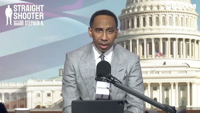 Stephen A. Smith in a gray suit discussing Minnesota ICE slaying on Straight Shooter with the Capitol building in the background.