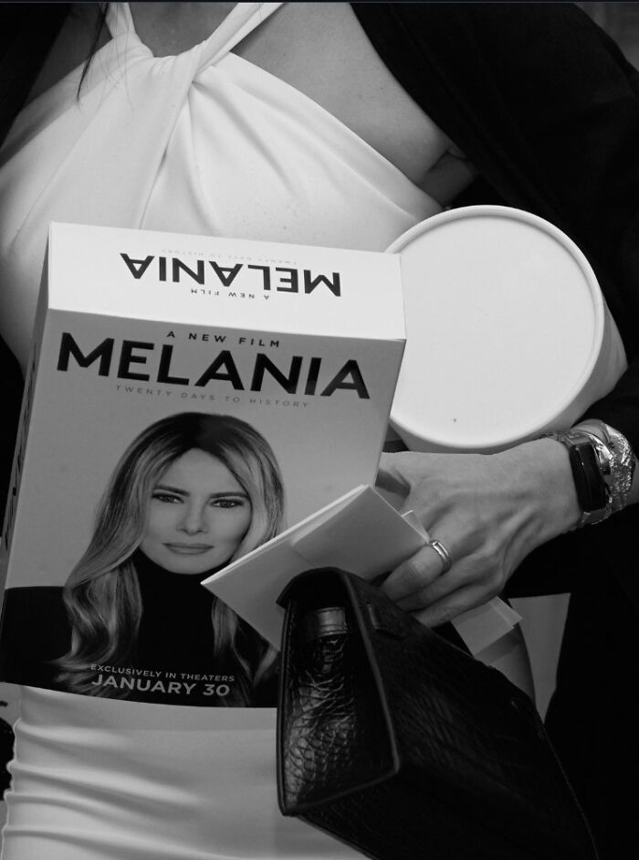 Person holding a Melania Trump documentary box and other items during a gaudy documentary screening event.