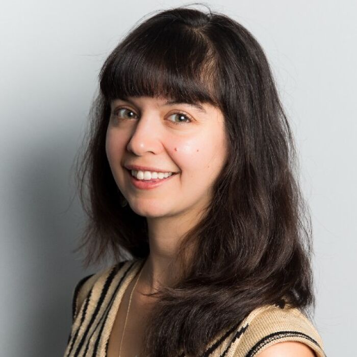 Young activist with dark hair and striped top speaks out after anti-ICE cookies cause threats against bakery.