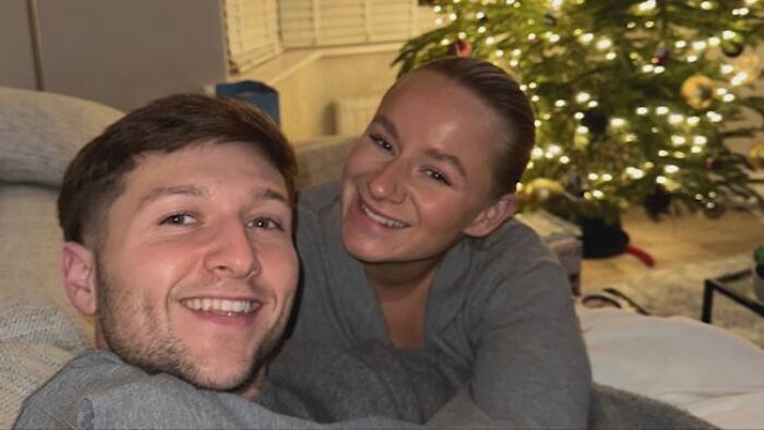 Young woman and man smiling indoors near Christmas tree, related to father fatally shooting daughter after Trump altercation.