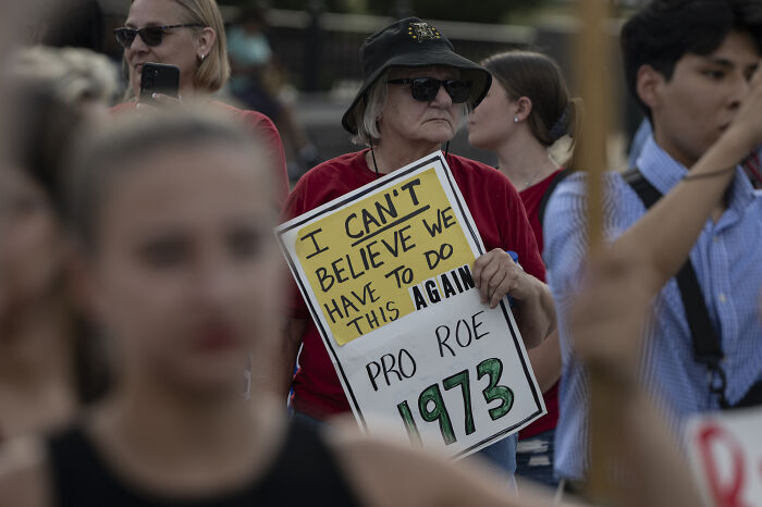 Woman at protest holding a sign about Roe 1973, reflecting views on MAGA ideologies women reveal they cannot handle on dates.