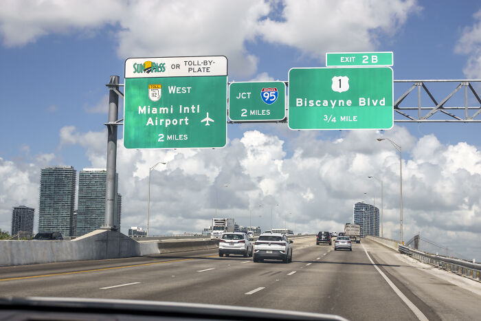 Highway signs near Miami International Airport showing directions under Florida&rsquo;s new law causing public confusion.