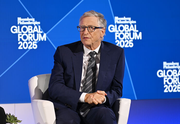 Bill Gates in a suit and glasses speaking at Bloomberg Philanthropies Global Forum 2025 on emerging disturbing details.