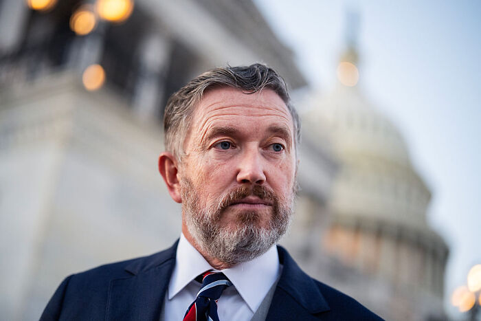 Middle-aged man in suit and tie standing near Capitol building, symbolizing Republicans discussed by Marjorie Taylor Greene.