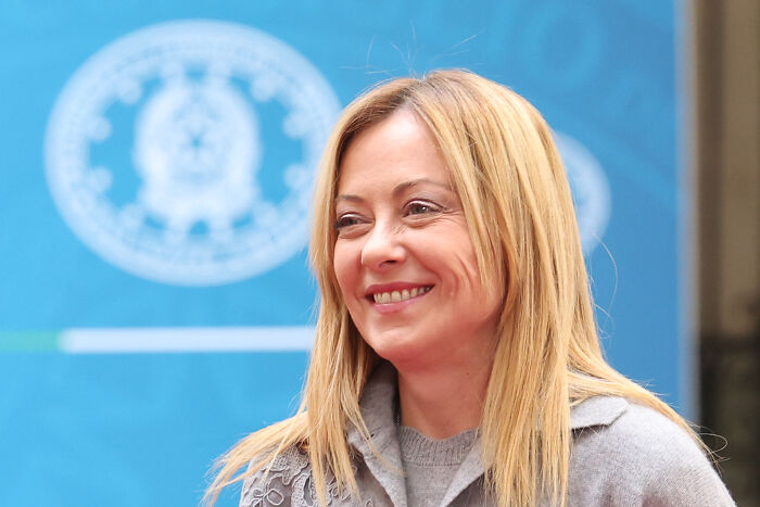 Smiling woman with blonde hair in front of a blue backdrop, related to Pope&rsquo;s Diocese of Rome church fresco restoration.