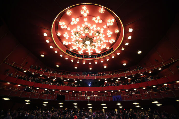Interior view of the Kennedy Center with a large chandelier and audience seating before renovation announcement.