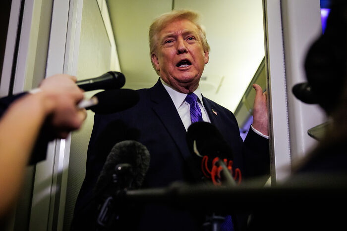 Donald Trump speaking to reporters in a hallway, reacting to U.S. Olympic athlete's mixed emotions in a fresh clash.