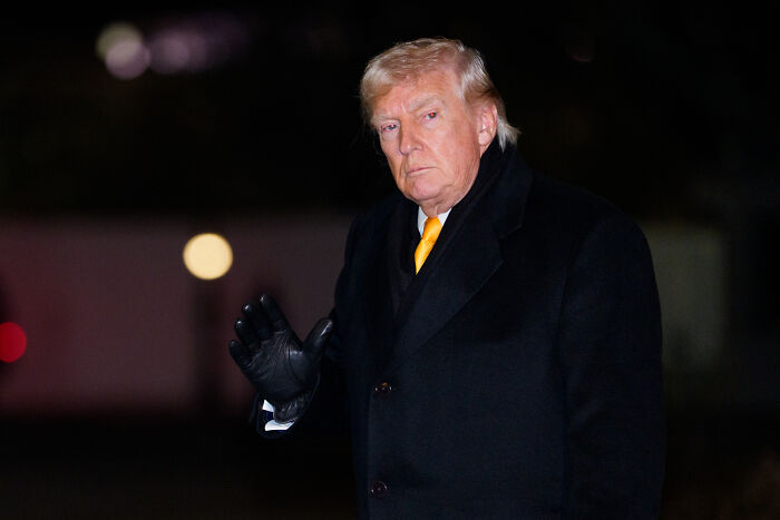 Donald Trump outdoors at night wearing a black coat and yellow tie, related to U.S. Olympian Hunter Hess response.