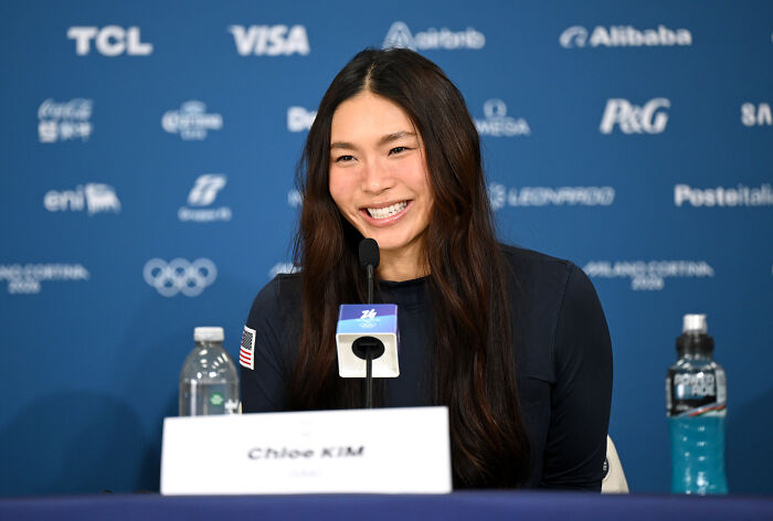 U.S. Olympian Hunter Hess speaking at a press conference, smiling and responding to comments with an unexpected retort.