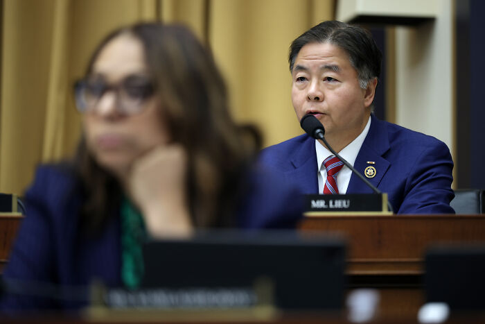 Representative Lee speaking into a microphone during a House Democrats meeting amid Bondi shouting match.