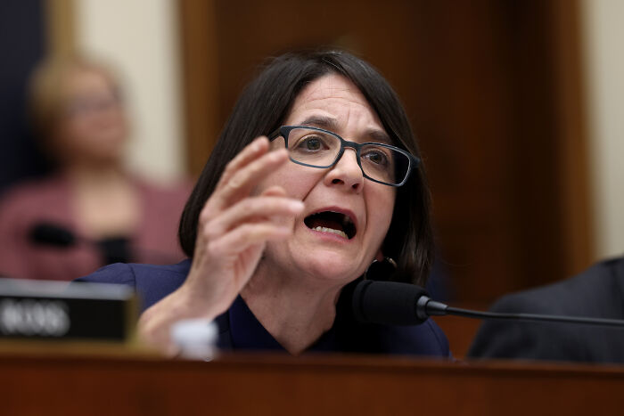 Woman with short dark hair and glasses speaking passionately during a House Democrats meeting amid shouting match with Bondi.