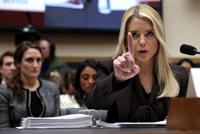 Bondi speaking assertively during a congressional hearing with House Democrats, holding up one finger for emphasis.