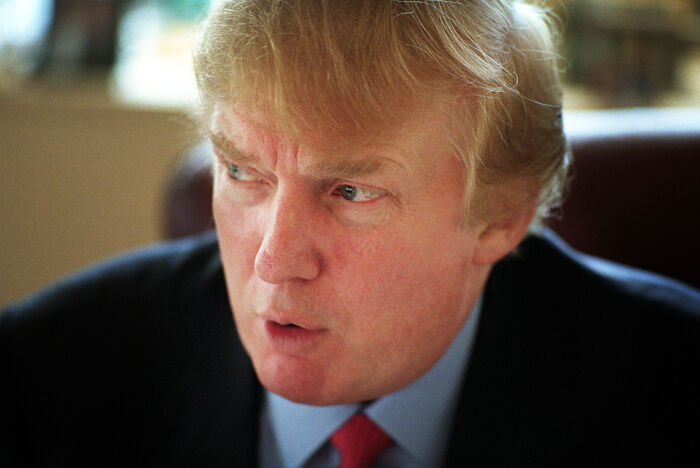 Close-up of a man with blond hair wearing a suit, captured in a serious moment related to vanished Mexican model claims.