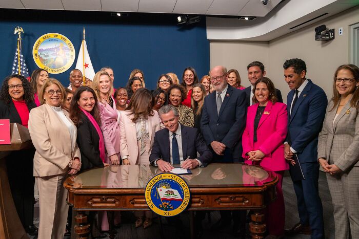 Jennifer Siebel Newsom with group of diverse women and men at California governor&rsquo;s office during official event.