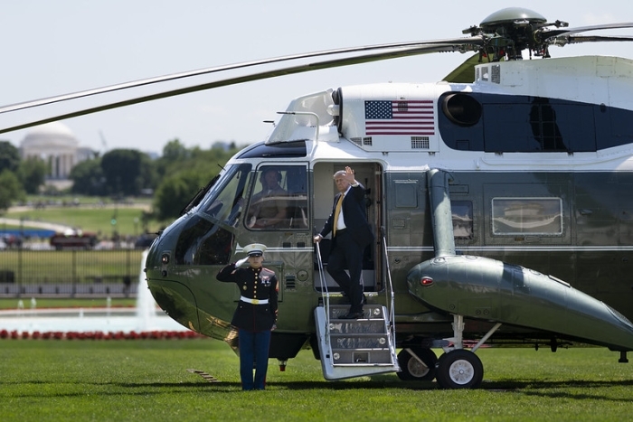Donald Trump waving while exiting a helicopter with US flag, connected to Indian Ocean islands report