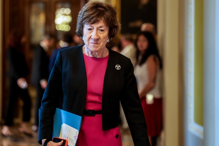 Susan Collins in a hallway, focused expression, political setting