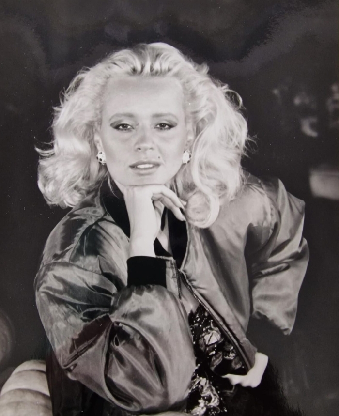 A glamorous blonde beauty queen poses for a photo, part of the story alleging Trump threatened her.