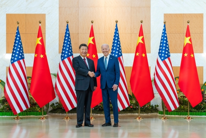 Trump election bombshell: President Joe Biden and Chinese President Xi Jinping shake hands with flags in background.